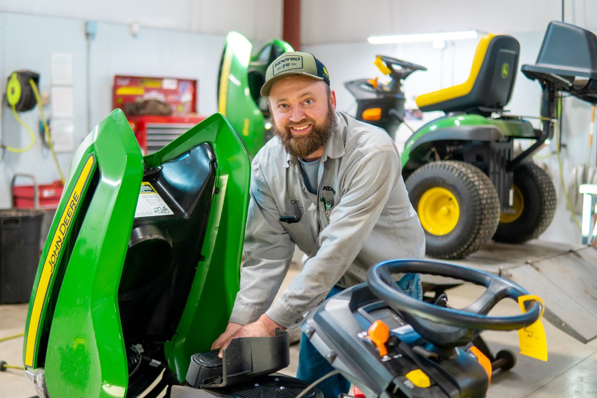 Koenig technician servicing a John Deere riding mower in the Knightstown shop