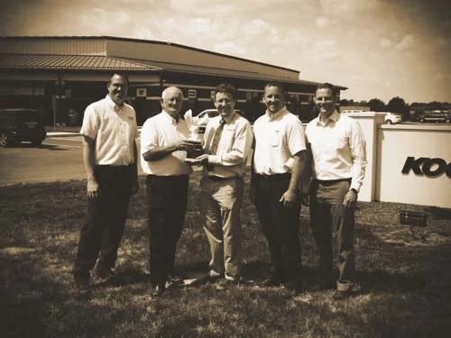 Historic photo of the Koenig Equipment team in front of a store