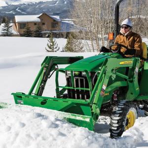 Person driving 3e utility tractor in the snow